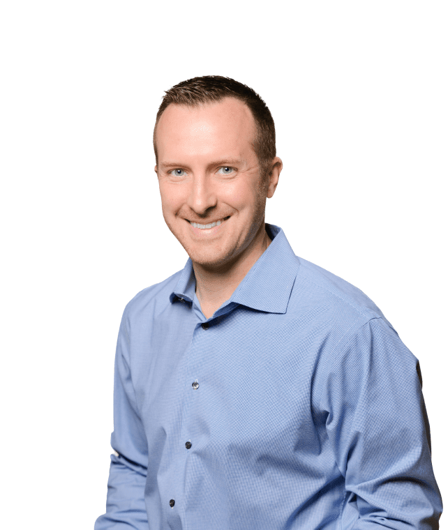 Professional man in a blue shirt smiling confidently against a white background.